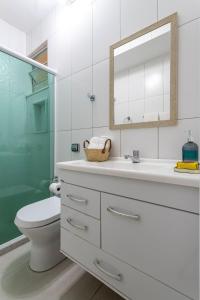 um banheiro com um vaso sanitário, uma pia e um espelho em Quiet apartment 6 minutes from Copacabana beach! no Rio de Janeiro mais 11 fotografias