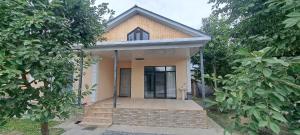 una pequeña casa con porche delantero y puerta en Cozy Home, en Gabala