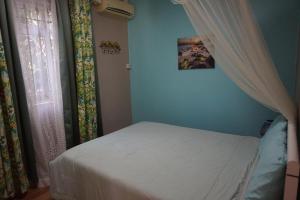 une chambre avec un lit et une fenêtre avec des rideaux dans l'établissement Captains Quarters Poolside Villa, à Flic-en-Flac 30 autres photos