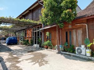 a house with a pergola on the side of it at Mas Jenar Guesthose by Kawulastay in Timuran