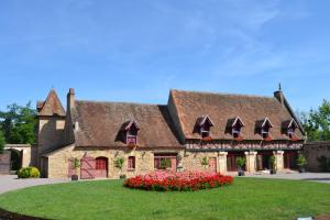 une grande maison avec des fleurs devant elle dans l'établissement Château de Peufeilhoux, à Vallon-en-Sully