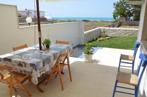 a table and chairs on the balcony of a house at Sabbia Dorata in Punta Braccetto