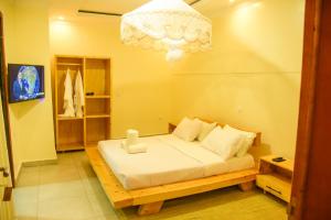 a bedroom with a bed and a chandelier at HOLY LAND RESORT Rw in Ruhengeri