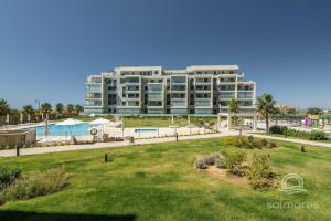a large building with a park in front of it at Los Camaleones EXCELLENT & SOLMARES in Isla Canela