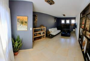 ein Wohnzimmer mit blauen Wänden und einer Couch in der Unterkunft Alojamiento ideal en zona norte de Córdoba Capital in Cordoba
