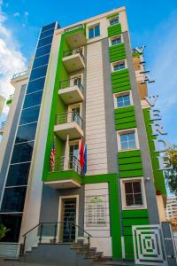 Ein hohes Gebäude mit zwei Fahnen drauf. in der Unterkunft Hotel Vila Verde City Center in Tirana