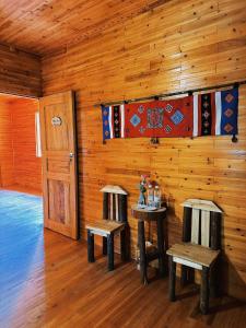 a room with two tables and benches in a cabin at Amazing Lô Lô Chải Homestay in Dồng Văn