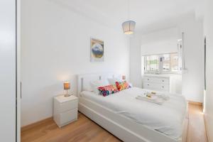 a white bedroom with a white bed and a window at Benfica City Flat Stay By Perfect Getaway in Damaia