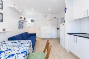 a kitchen and a living room with a blue couch at Benfica City Flat Stay By Perfect Getaway in Damaia