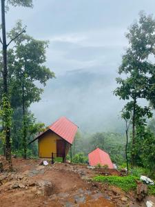 two small houses with red roofs on a hill at Paithal View Retreat in Paithalmala