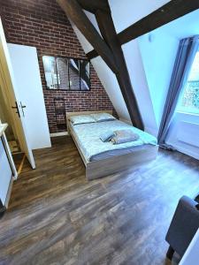 a bedroom with a bed in a brick wall at Jolie studio en cetre ville de Montluçon 20 min à pieds de la gare in Montluçon