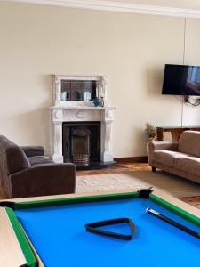 a living room with a pool table and a fireplace at IEC Campus for Groups in Kanturk
