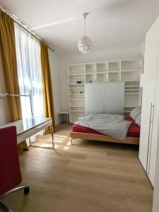 a bedroom with a bed and a desk and a window at Cosy Apartment close to Oktoberfest, best infrastructure, parking included in Munich