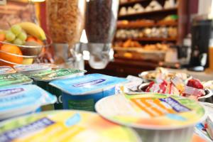 a table with plates of food and a bowl of fruit at hôtel QUICK Palace Tours Nord in Tours