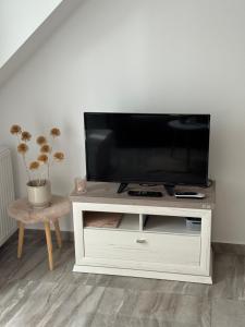 a white entertainment center with a flat screen tv on it at Marót Apartman in Keszthely