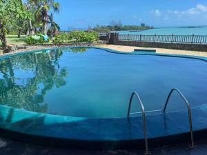 a large swimming pool with a view of the water at Greenyvilla in Calodyne
