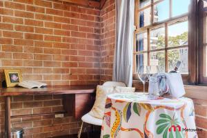 Zimmer mit einem Tisch und einer Ziegelwand in der Unterkunft MetaWiseBnB Studio Near Uni Broadway & Transport in Sydney