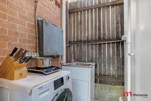 eine Küche mit einer Waschmaschine und einer Ziegelwand in der Unterkunft MetaWiseBnB Studio Near Uni Broadway & Transport in Sydney + 3 Fotos