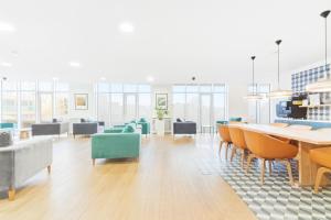 a large room with chairs and a table and a room with windows at Luxury 2BR Penthouse in Harrow with Balcony, Private Gym, Games Room & Guests Lounge in Harrow