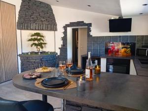 a kitchen with a table with two glasses of wine at Casa Lova Spa Privé, Clim,Baignoire balnéo in Entraigues-sur-la-Sorgue