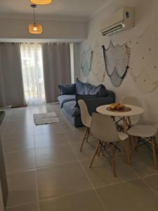 ein Wohnzimmer mit einer Couch und einem Tisch und Stühlen in der Unterkunft Youd ResortNorthcoast 2 bedroom appartment in El-Alamein
