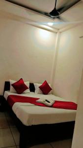 a bed in a room with red pillows on it at Hotel The Grand Avanti in Ujjain