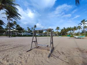 a swing set on a beach with palm trees at Alana Seaview by CKV - Free Airport Pick Up in Phu Quoc