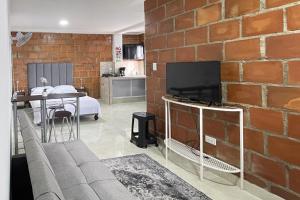 a living room with a brick wall at Apartamentos cerca a canchas Panamericanas Barrio Olimpico - Luxury Apartments in Cali