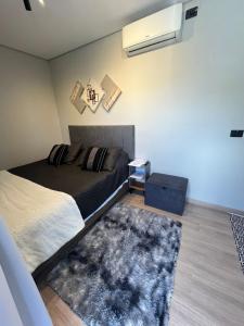 a bedroom with a bed and a rug at São Roque Chalés in São Roque