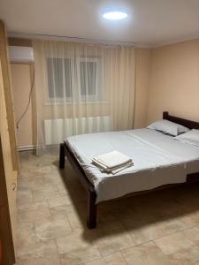 a bedroom with a bed with white sheets and a window at Hotel Giurgiulești in Giurgiuleşti