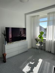 a living room with a large tv on a dresser at Однокімнатна квартира in Nærum