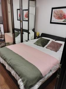 a bedroom with a large bed with two pillows at Urban Elegance Studio & SPA in Niš