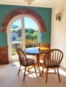 a dining room with a table and two chairs and a window at Hawthorn Valley Views in Wroxall