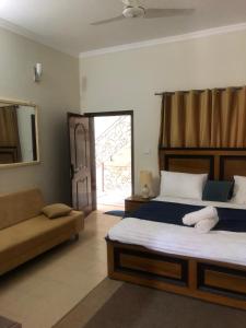 a bedroom with a bed and a couch and a window at Mountain View Resort in Islamabad