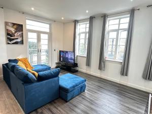 a living room with a blue couch and a tv at Nottingham City Centre 3 Bed Luxury Apartment in Nottingham