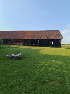a large green field with a building and a tub at Siedlisko Wilczyny  +6 photos