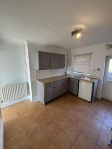 an empty kitchen with a sink and a dishwasher at Cheap Grantham Town Centre Terrace House in Lincolnshire