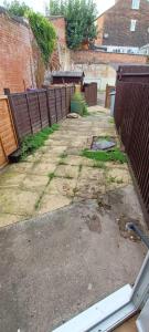 an empty driveway with a fence and a building at Cheap Grantham Town Centre Terrace House in Lincolnshire