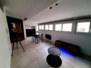 a living room with a table and some windows at Le Cocon in Meudon