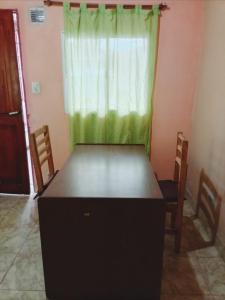 a table in a room with a green curtain at La Terminal Monoambiente en casa familiar in San Salvador de Jujuy