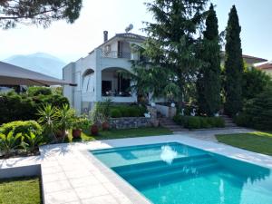 a swimming pool in front of a house at Villa with Private Pool by the coast of Olympus in Leptokarya