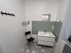 a bathroom with a sink and a chair in it at Le Paquebot - Near Les Chantiers de l'Atlantique in Saint-Nazaire
