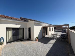 a patio of a house with a table and chairs at Les Crechois in Crêches-sur-Saône