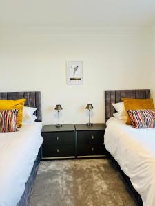 two beds sitting next to each other in a room at Lewis Living in Aird Tong