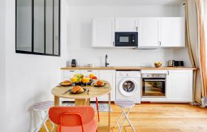 a kitchen with a wooden table with fruit on it at BnBNova - 1BR - Eiffel Tower & Rue Gros Caillou in Paris