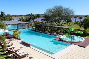 费德拉西翁竞技场度假村 的配有椅子和遮阳伞的大型游泳池