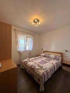 a bedroom with a bed and a window at Apartman 3 Majba in Zaglavice
