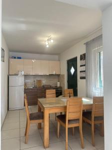 a kitchen with a table and chairs and a refrigerator at Apartman 3 Majba in Zaglavice