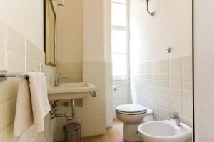La salle de bains blanche est pourvue de toilettes et d'un lavabo. dans l'établissement CS Cosy Termini Studio, à Rome