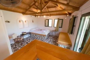 a room with a bed and a table and chairs at Casa Milos Stone Chalets in Alonnisos